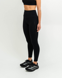 Side profile showing high-rise waistband and ankle-grazer fit