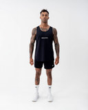 Full-length front view of a man in the black Nexletica Men's Perform Running Singlet with matching shorts, socks and running shoes