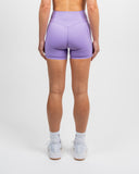 Back view of lilac Nexletica Impulse High Waist Shorts 5 inch highlighting contour seams and fit