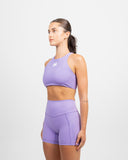 Three quarter side view of woman wearing lilac Impulse High Waist Shorts 5 inch and coordinating high neck bra
