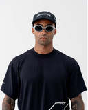 Side view of the black Nexletica Perform Hat showing the white outlined logo graphic and lightweight 5-panel construction